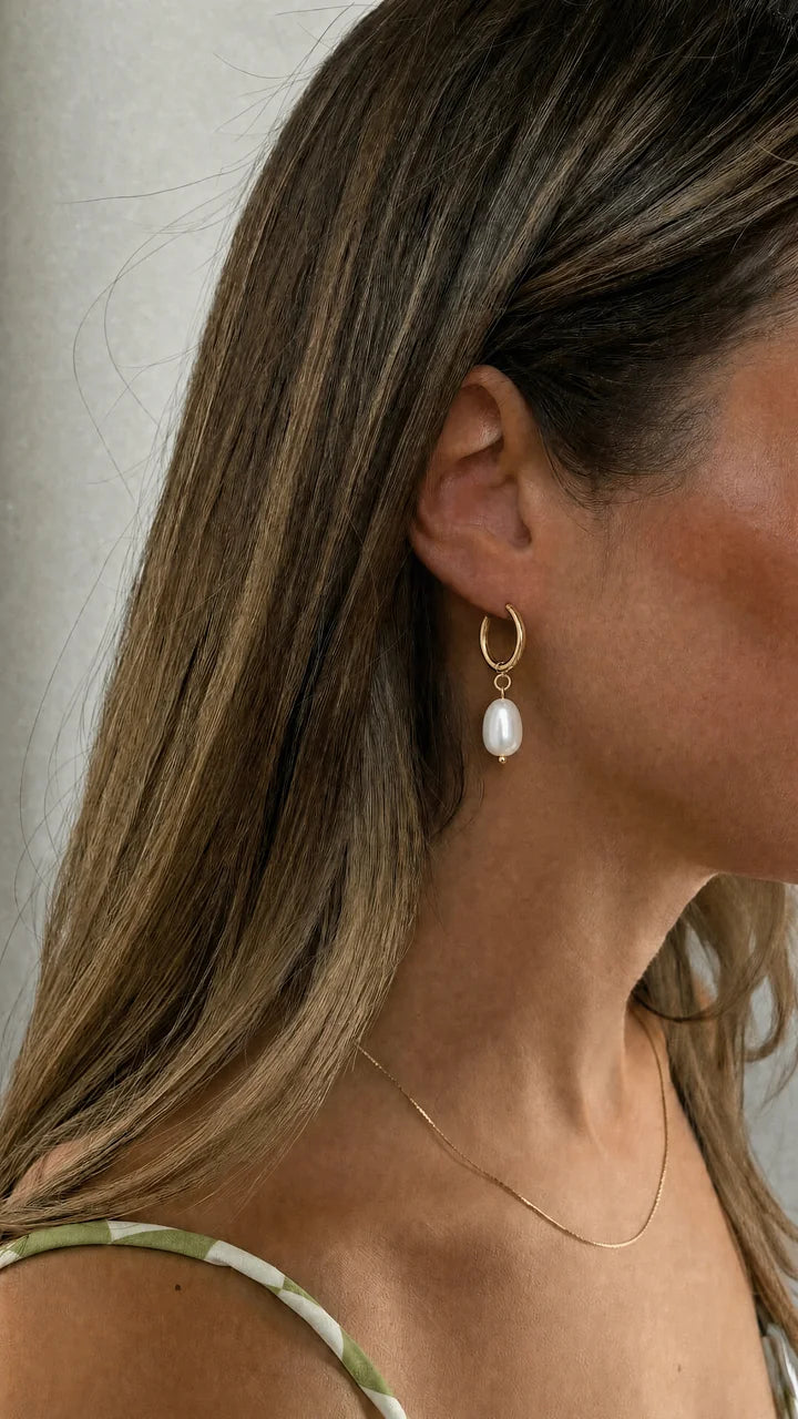 Aro dorado con perla colgante en la oreja