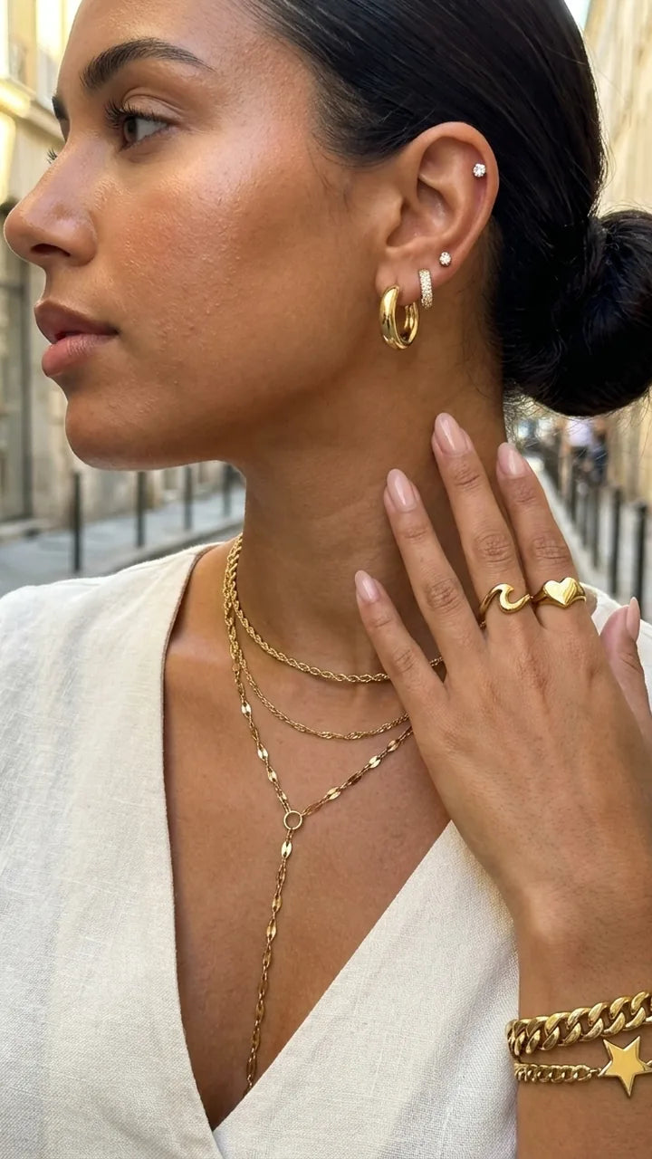 Aros dorados, collares en capas y pulsera de eslabones con estrella