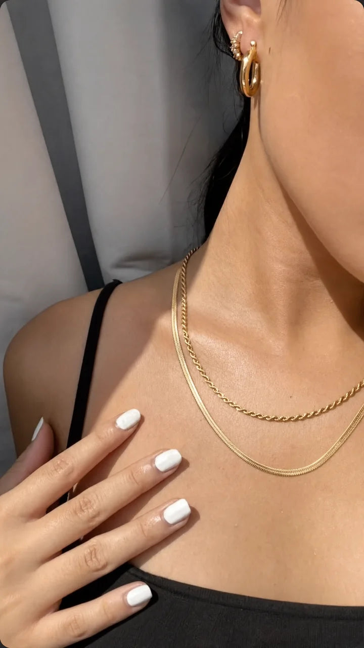Cadenas doradas en capas con top negro y aros
